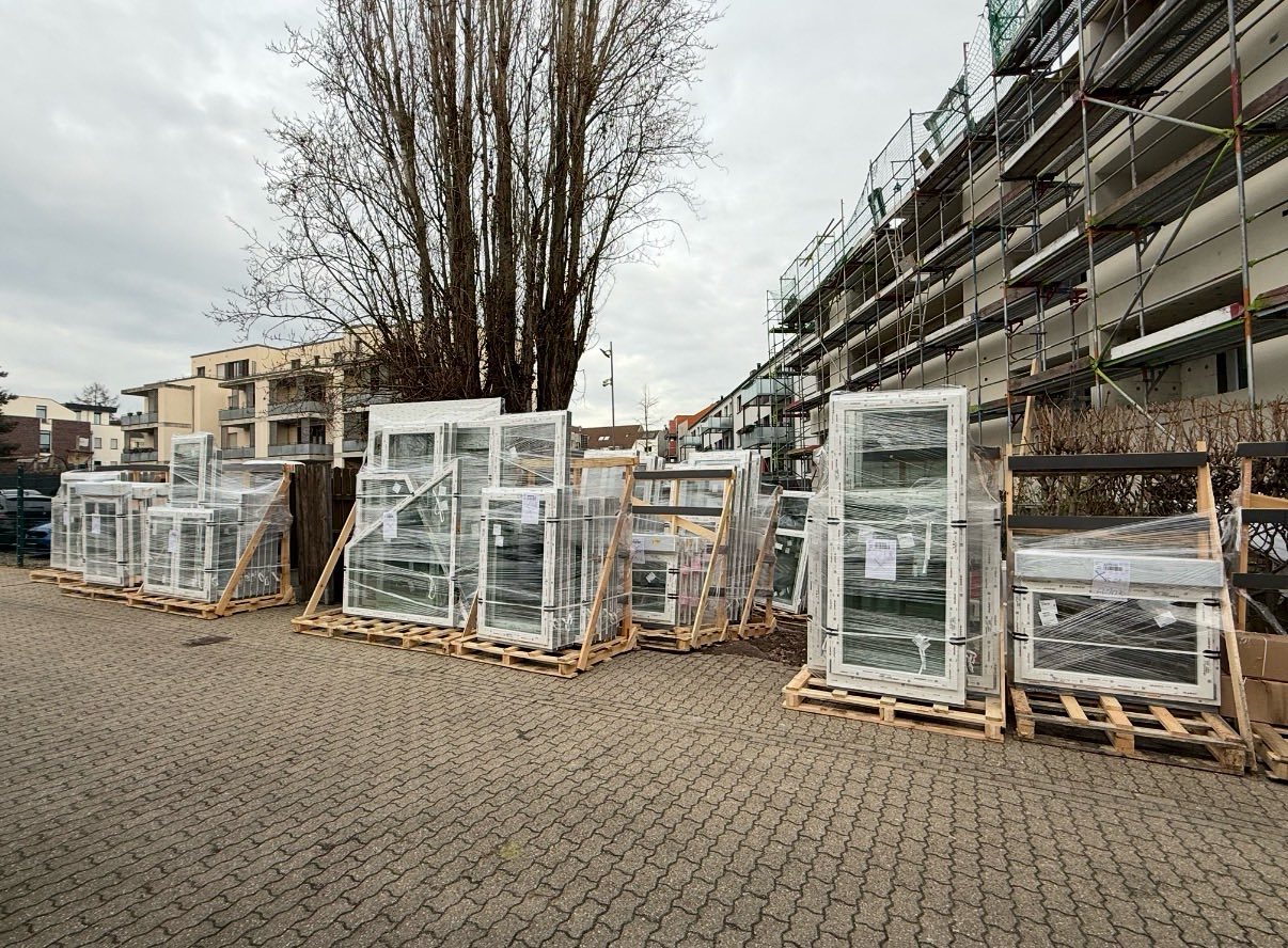 Neue Fensterelemente auf Paletten an einer Baustelle