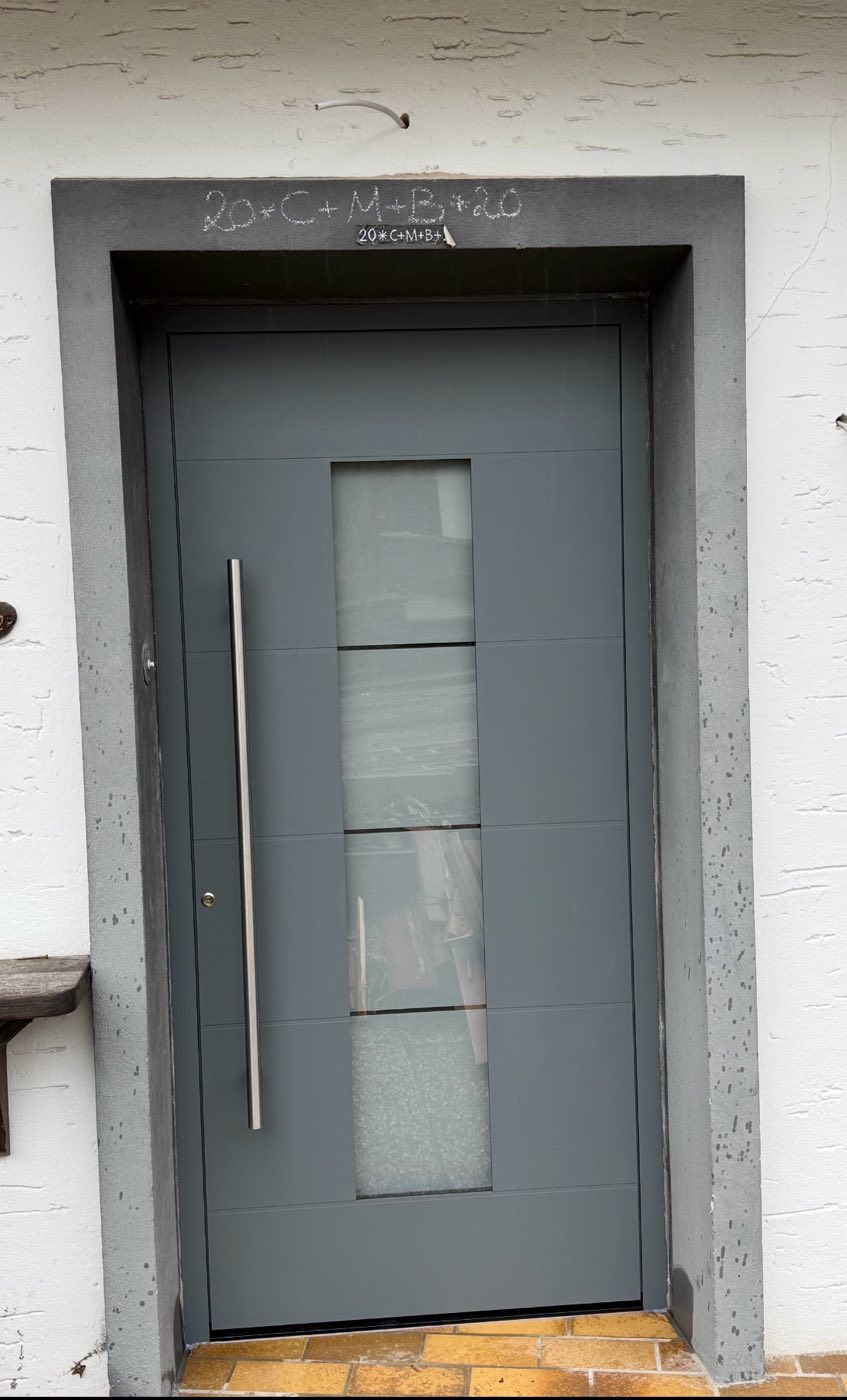 Anthrazitfarbene Haustür mit vier Glasfeldern und Stangengriff