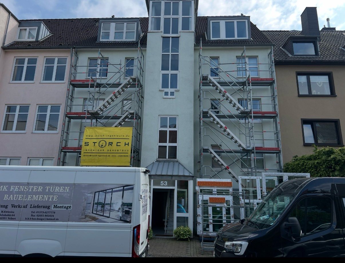 Mehrfamilienhaus mit Gerüst und Firmenwagen von MK Fenster